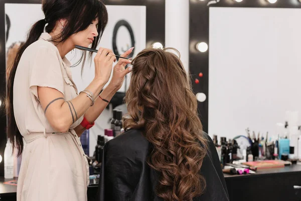 Menina com cabelo longo encaracolado marrom em um salão de beleza. Preparação de manhã da noiva — Fotografia de Stock
