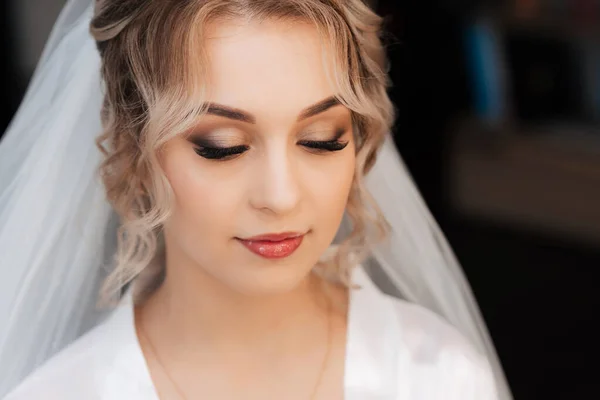 Retrato da noiva reunida no Estúdio de beleza, uma bela loira com cabelo e maquiagem em um véu nupcial. — Fotografia de Stock