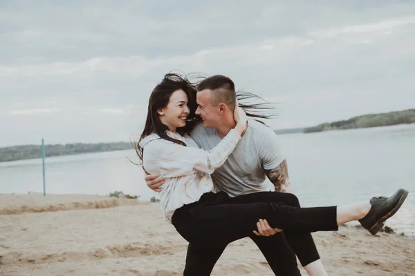 Jovem casal feliz se divertindo na areia na praia — Fotografia de Stock