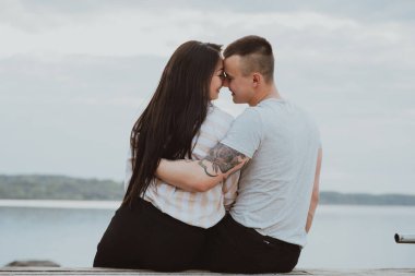 Kumsalda kucaklaşan mutlu çifti seviyorum.