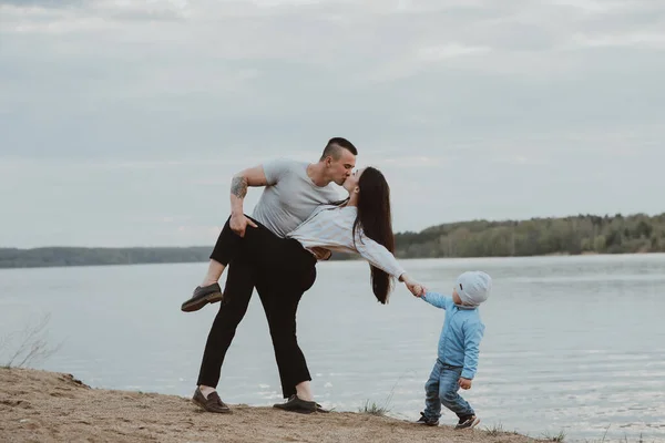 Young white family with their son on the beach on the sand