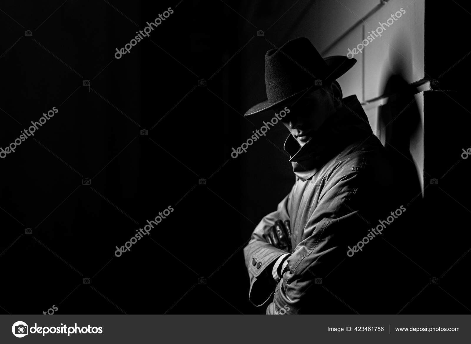 Dark silhouette of a man in a raincoat with a hat at night — Stock