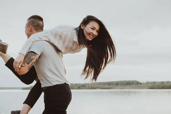 Glückliches Mädchen auf den Schultern ihres Freundes lächelnd und glücklich — Stockfoto