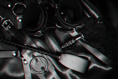 BDSM 'in egemen ve boyun eğen seks aksesuarları. Deri kamçı, kelepçe, boğucu ve anal tıkaç.