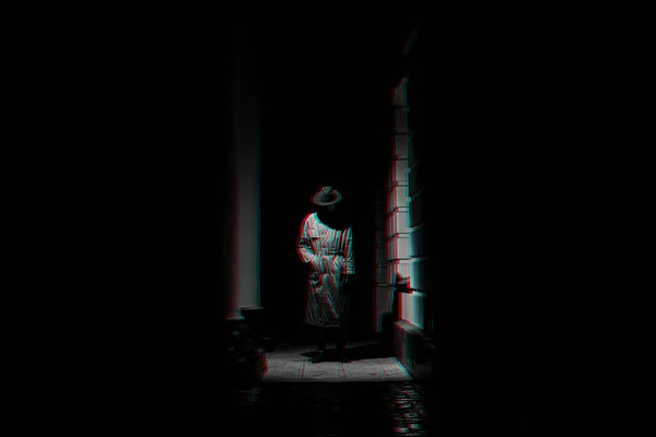 Sombre silhouette dramatique d'un homme dans un chapeau et imperméable la nuit dans la rue — Photo