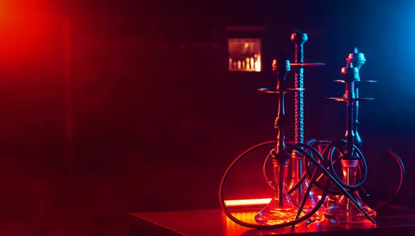 Hookahs with glass flasks and metal bowls on the table in the restaurant for traditional Eastern Turkish relaxation — Stock Photo, Image