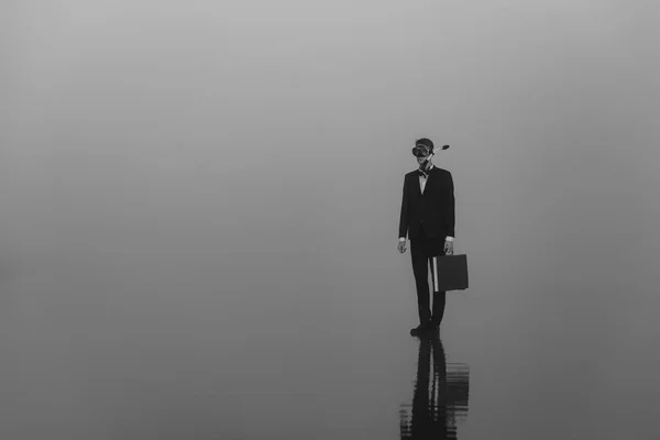 Сюрреалістичний портрет чоловіка таємний агент шпигун в костюмі і маска для дайвінгу і снорк з валізою в руці — стокове фото