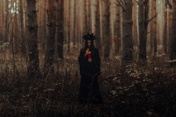 Dark terrible witch with candles in her hands performs an occult mystical ritual — Stock Photo, Image