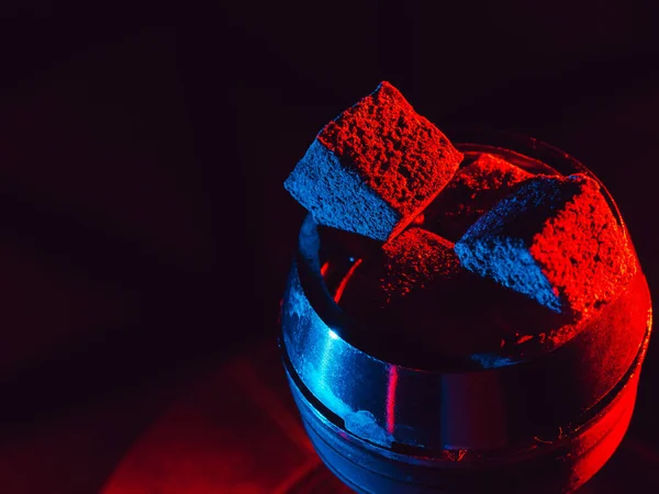 Charbons rouges chauds pour narguilé chicha dans un bol en métal avec éclairage au néon bleu rouge — Photo