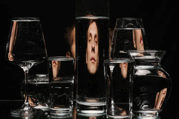 Портрет людини через склянку резервуара з водою з відображенням і спотвореннями — стокове фото