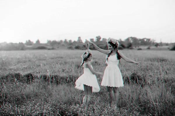 Szczęśliwa matka i córka w białych sukienkach wirują i mają radość i szczęście w lecie — Zdjęcie stockowe