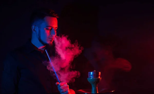 Чоловічий курець курить кальян у шайбі і випускає хмару диму — стокове фото