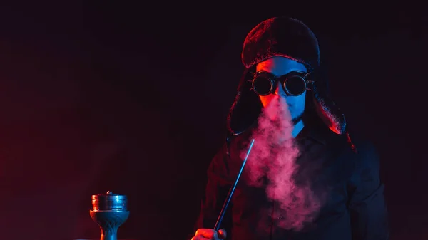Bearded man smokes a shisha in a hookah bar and blows a cloud of smoke — Stock Photo, Image