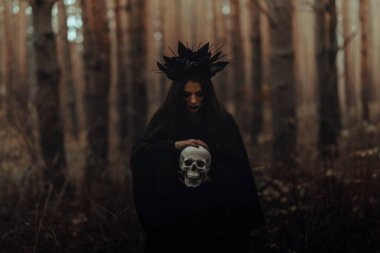 Siyah kostümlü bir cadı kızın siyah portresi.