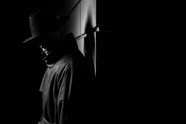Ciemna sylwetka mężczyzny w płaszczu przeciwdeszczowym z kapeluszem w nocy — Zdjęcie stockowe