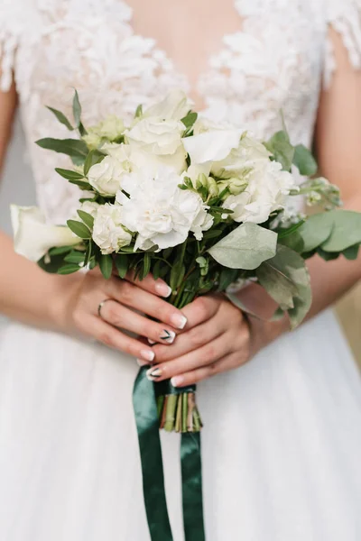 Bouquet de mariage de roses blanches dans les mains de la mariée — Photo