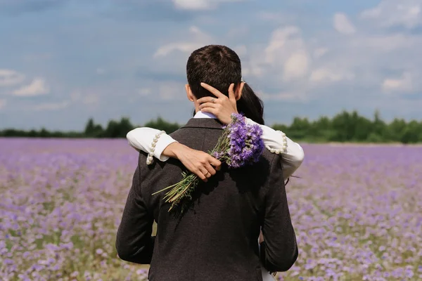 Braut und Bräutigam am Hochzeitstag in einem Feld aus Sommerblumen — Stockfoto