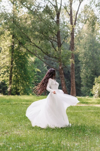 白いドレスの花嫁が公園の掃除で結婚式の日に旋回する — ストック写真