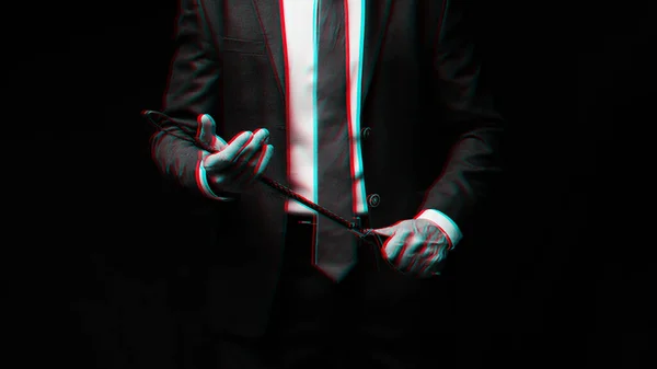 Male dominant businessman in a suit holding a leather whip Flogger for domination — Stock Photo, Image