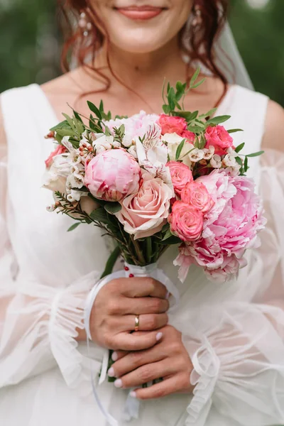 Bouquet de mariage de roses blanches et roses et pivoines dans les mains de la mariée — Photo