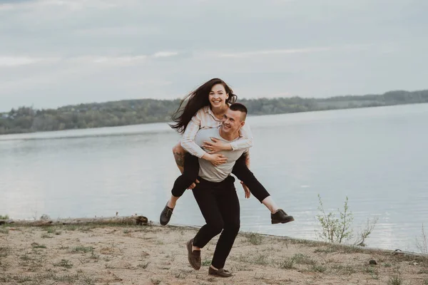 Chica feliz en los hombros de su novio sonriente y feliz —  Fotos de Stock