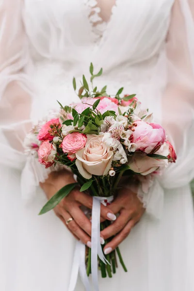 Svatební kytice z bílých a růžových růží a pivoňky v rukou nevěsty — Stock fotografie