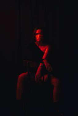 Sandalyede oturan zihinsel sorunları olan bir kızın bulanık portresi.