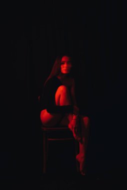 Sandalyede oturan zihinsel sorunları olan bir kızın bulanık portresi.