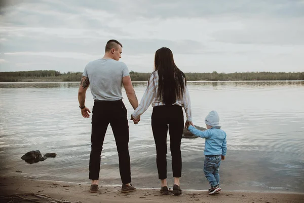 Young white family with their son on the beach on the sand