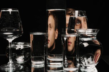 Tankın camından yansımaları ve çarpıtmaları olan bir adamın portresi.