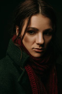 Paltolu ve atkılı bir kızın dramatik portresi