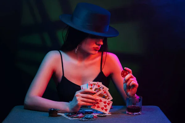 Jogador de poker em uma mesa de casino com cartões e fichas — Fotografia de Stock