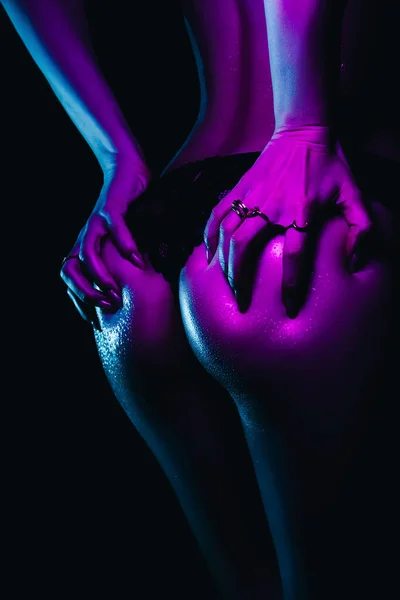 Big sexy ass of girl with slim figure with neon light. Womans body in drops water and sweat — Stock Photo, Image