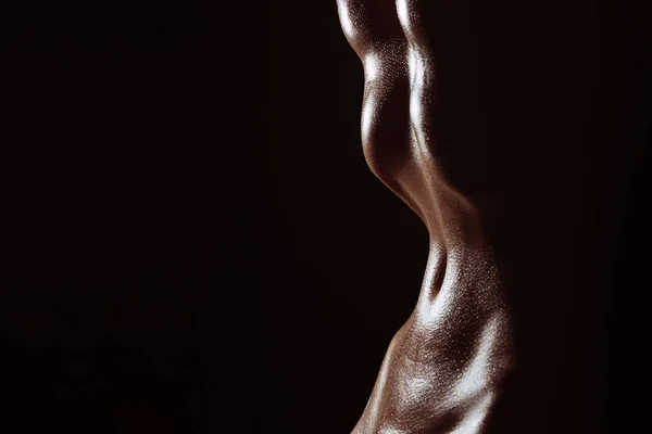 Schlanke Taille eines nackten Mädchens. Silhouette des nassen Bauches in Schweißtropfen auf dunklem Hintergrund — Stockfoto