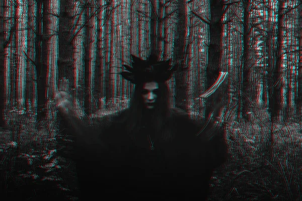 Hexe in schwarzem Kostüm führt dunkle Zaubersprüche mit Kerzen im Wald auf — Stockfoto