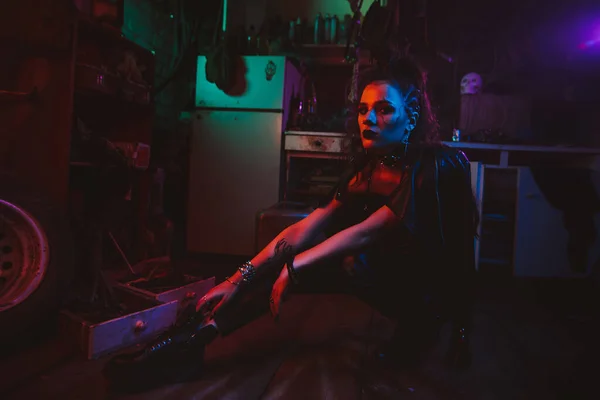 Cyberpunk girl in a steampunk costume in a garage with neon lighting — Stockfoto