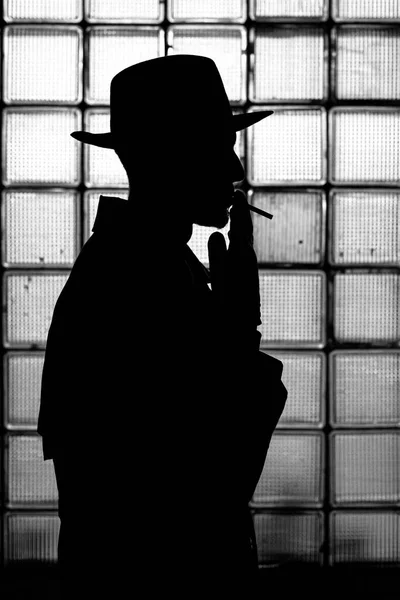 Ciemna mistyczna sylwetka mężczyzny w kapeluszu palącego papierosa — Zdjęcie stockowe