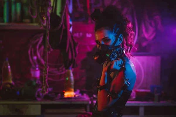 Cosplay cyberpunk. Una chica con una máscara de gas en un estilo post-apocalíptico con iluminación de neón — Foto de Stock