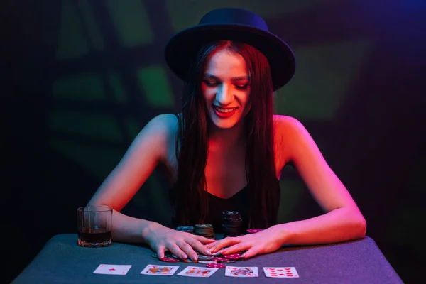 girl winner plays poker at the table with chips and cards in the casino