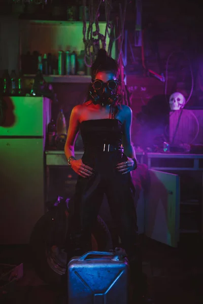 Fille soldat dans le style cyberpunk avec un masque à gaz et des lunettes avec éclairage au néon dans le garage. Style Steampunk — Photo