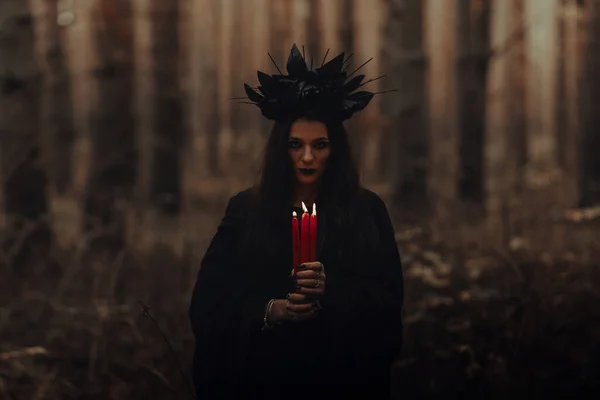 Preto terrível bruxa detém velas em suas mãos — Fotografia de Stock