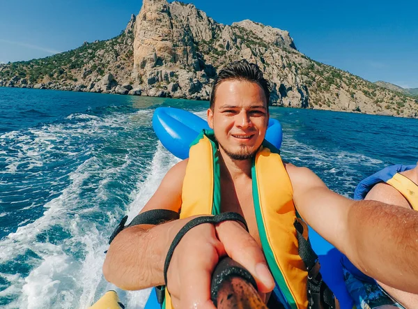 Boldog ember lovagol egy banán hajó egy nyaralás a tengeren — Stock Fotó
