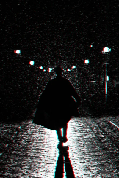 Dramatic silhouette of a man in a hat and raincoat walking through the city at night — Stock Photo, Image