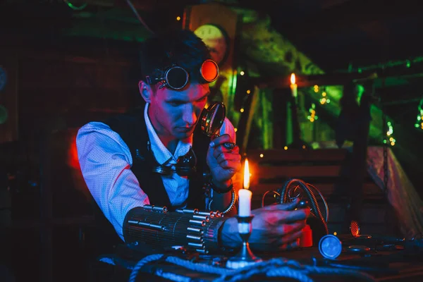 男发明家穿着蒸汽灌装在餐桌旁修理一个神奇的机械装置 — 图库照片
