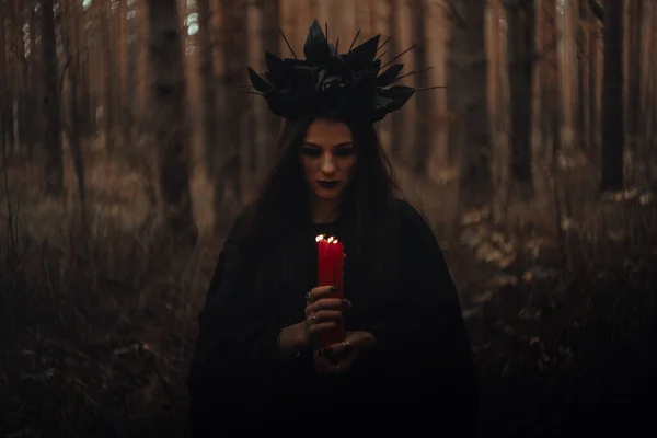 Bruxa terrível escura com velas em suas mãos executa um ritual místico oculto — Fotografia de Stock