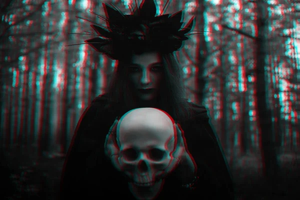 Portret van een verschrikkelijke heks met een schedel in de handen van een dode voert een occult mystiek ritueel uit — Stockfoto