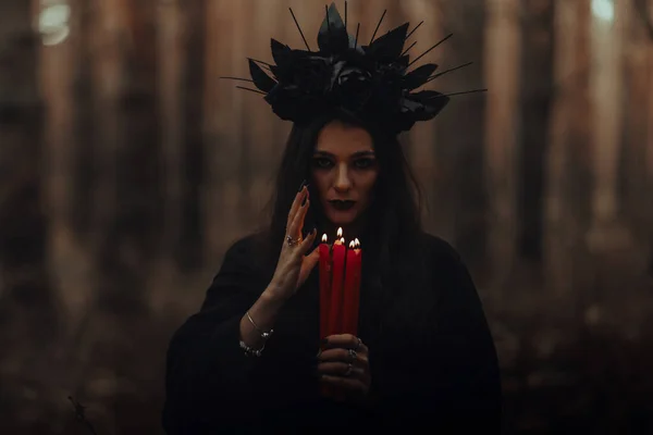 Noir terrible sorcière tient des bougies dans ses mains — Photo