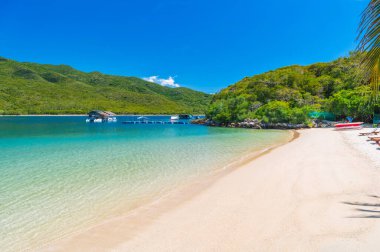 Yazın deniz kenarında kumlu bir sahil. Adadaki tropik lüks tatil köyü. Egzotik okyanus manzaralı manzara