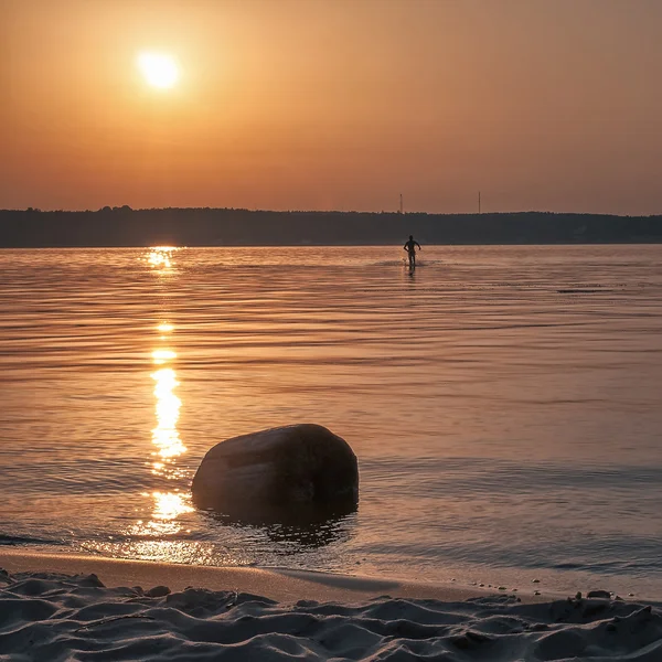 Silhouette di un uomo che corre sull'acqua al tramonto — Foto Stock