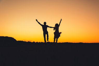Yaz aylarında gün batımında sevinçle atlama Çift